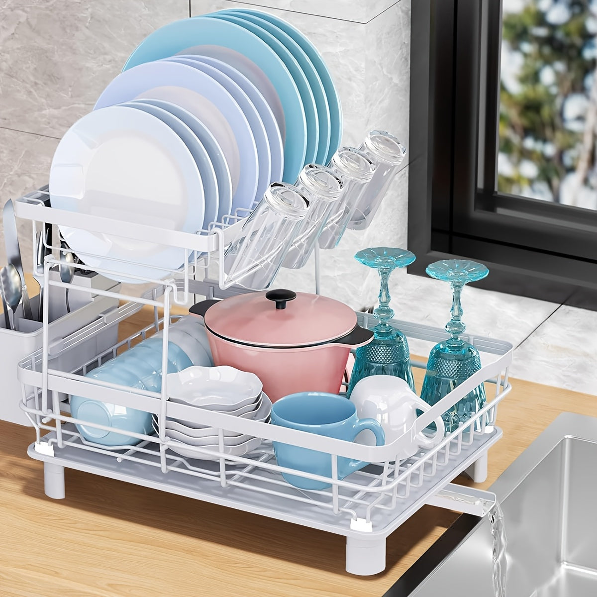 Two-tier stainless steel dish drying rack with utensil holder and drain board on a kitchen counter